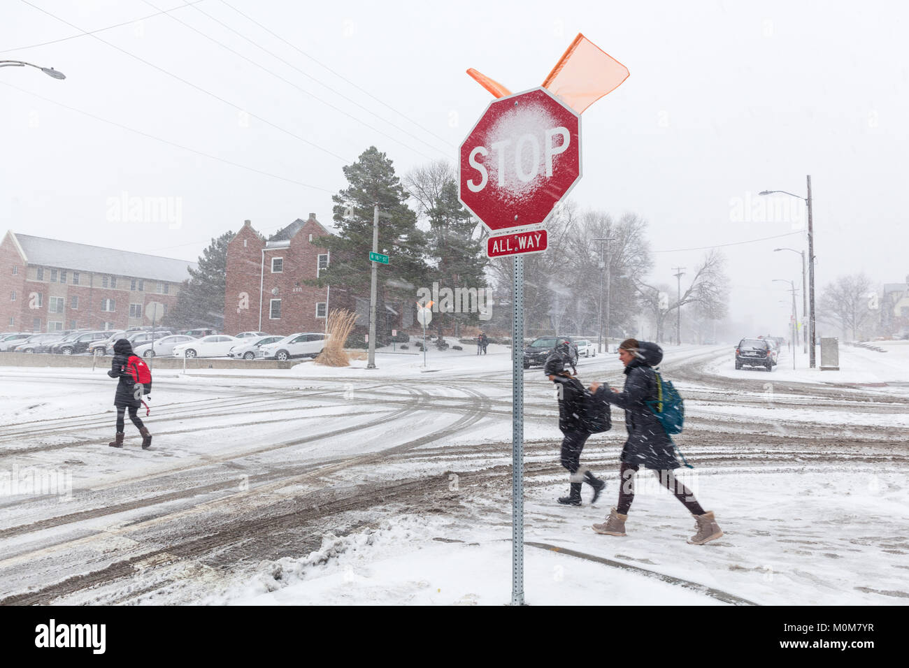 Lincoln, USA. 22nd Jan, 2018. Students at the University of Nebraska in Lincoln, NE begin to cross a snow covered street during a snowstorm. Credit: LorenRyePhoto/Alamy Live News Stock Photo
