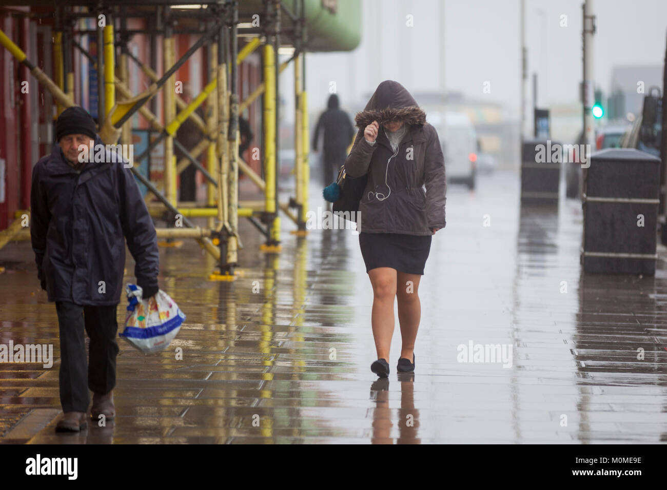 Hastings, East Sussex, UK. 23rd Jan, 2018. Raining in Hastings with low visibility on the roads making driving conditions difficult. Lots of people walking about in the rain which shows no signs of stopping. This woman adjusts her hood to keep out the rain. Photo Credit: Paul Lawrenson/Alamy Live News Stock Photo