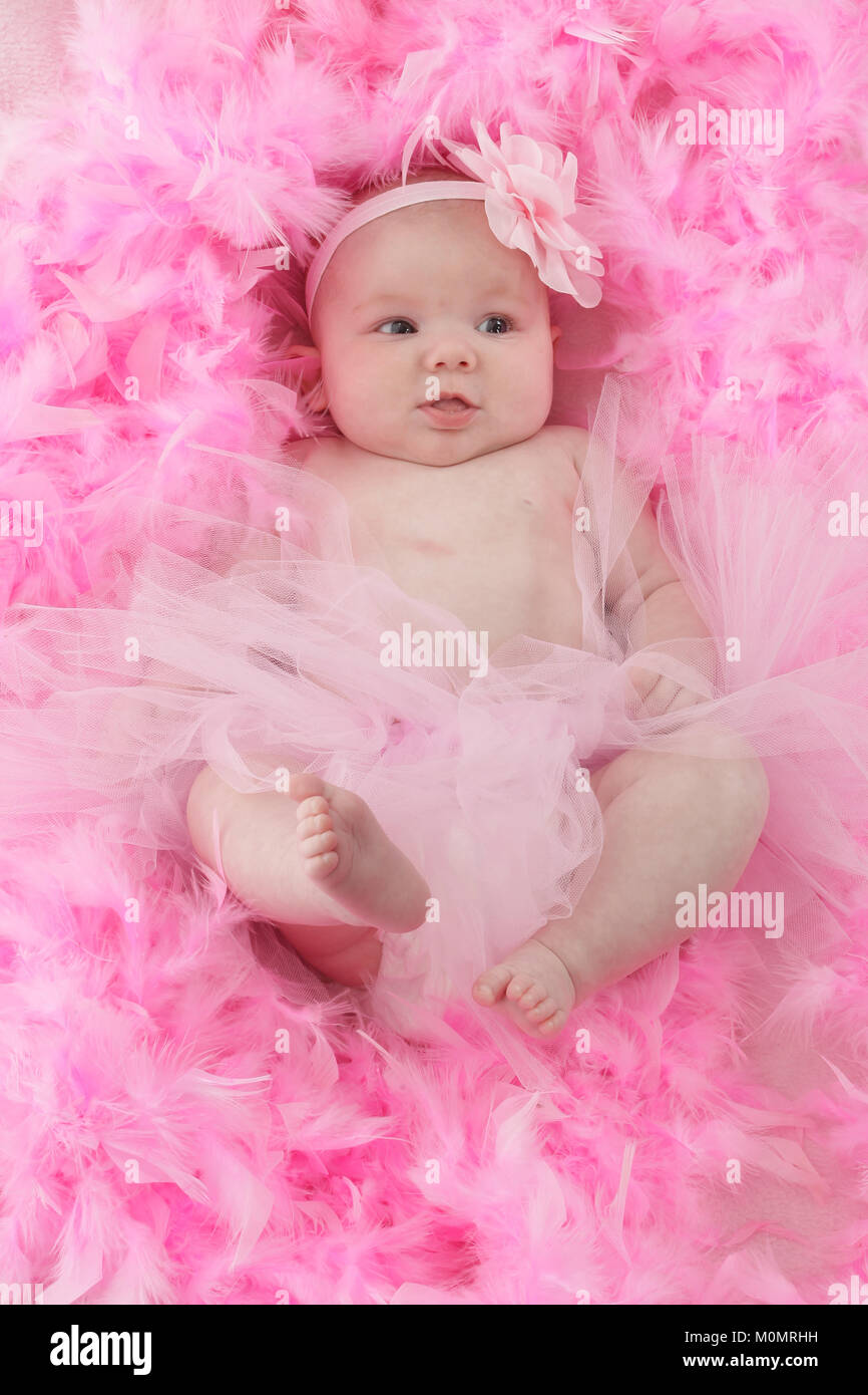 Infant on soft feather bed, baby girl Stock Photo Alamy