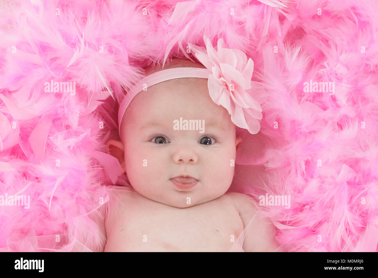 Infant on soft feather bed, baby girl Stock Photo Alamy