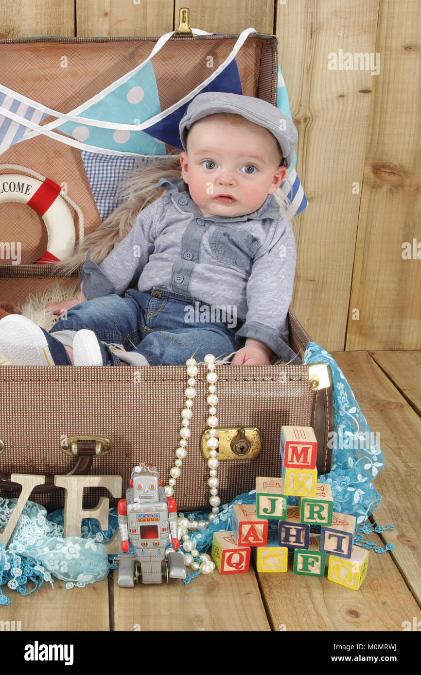 baby boy flat cap in vintage suitcase Stock Photo Alamy