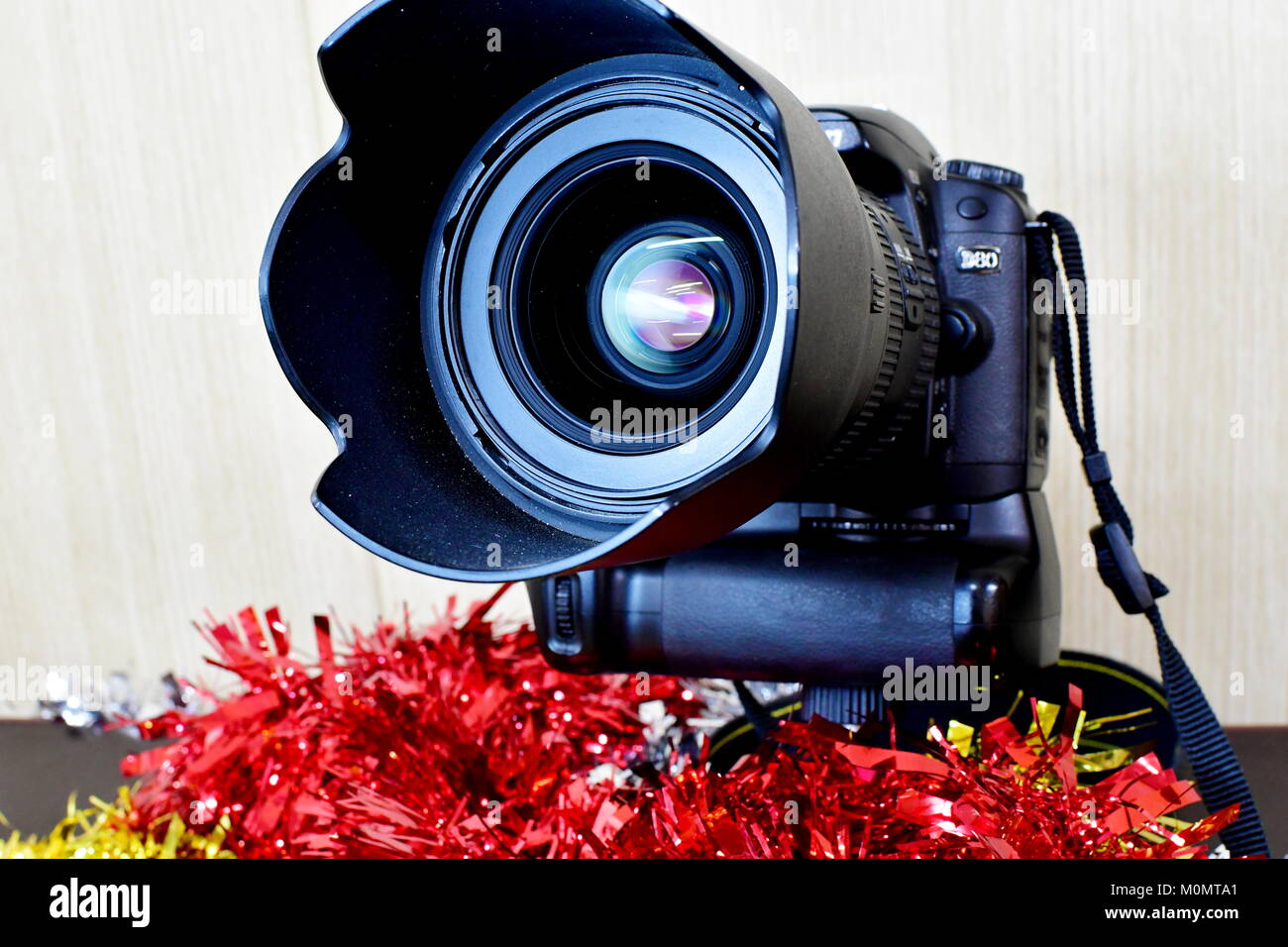 Nikon DSLR D80 and battery pack and Lenses on display and Christmas decorations as well Stock Photo