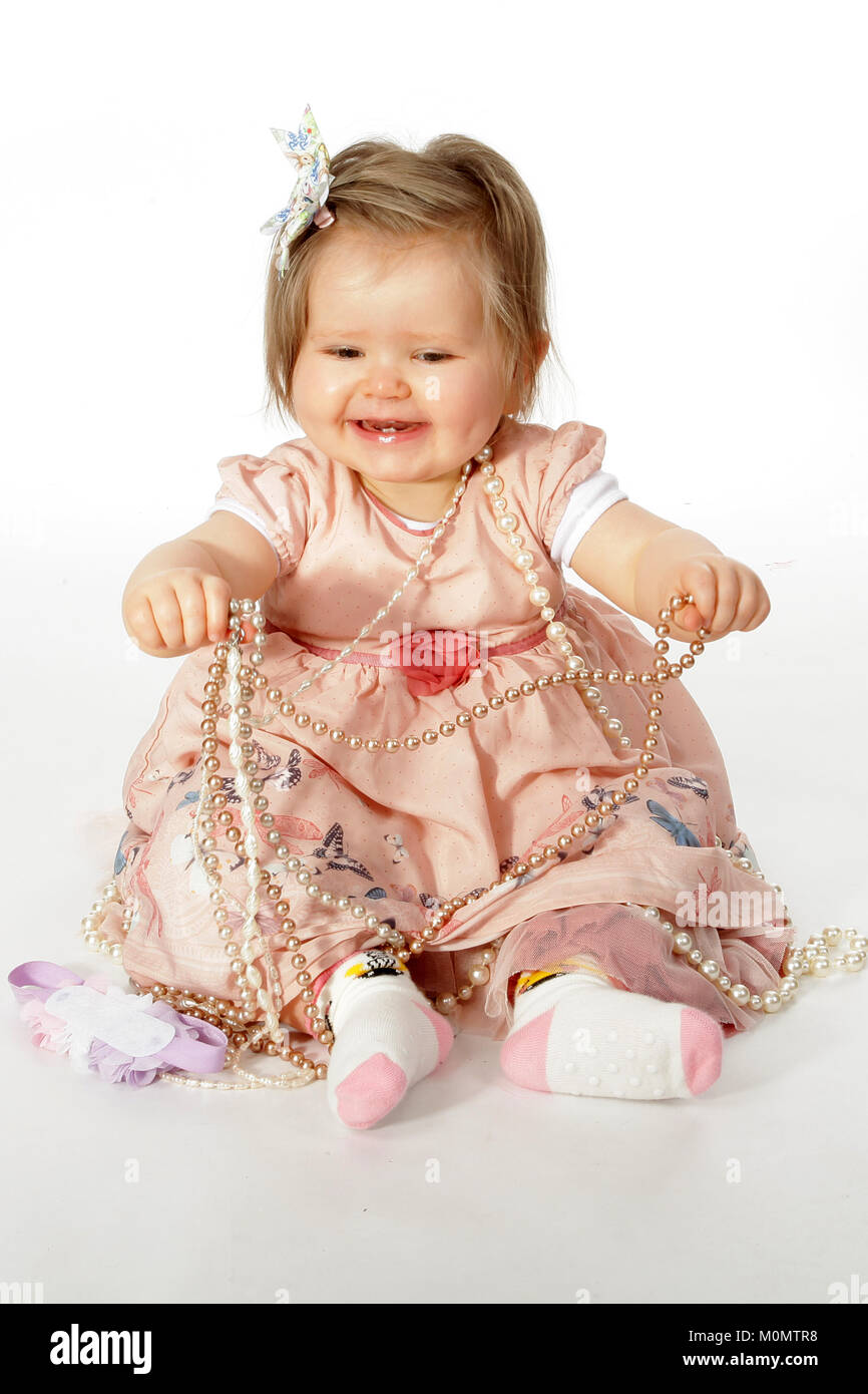 1 year old beautiful girl in pretty dress, child development, personal and social skills Stock Photo