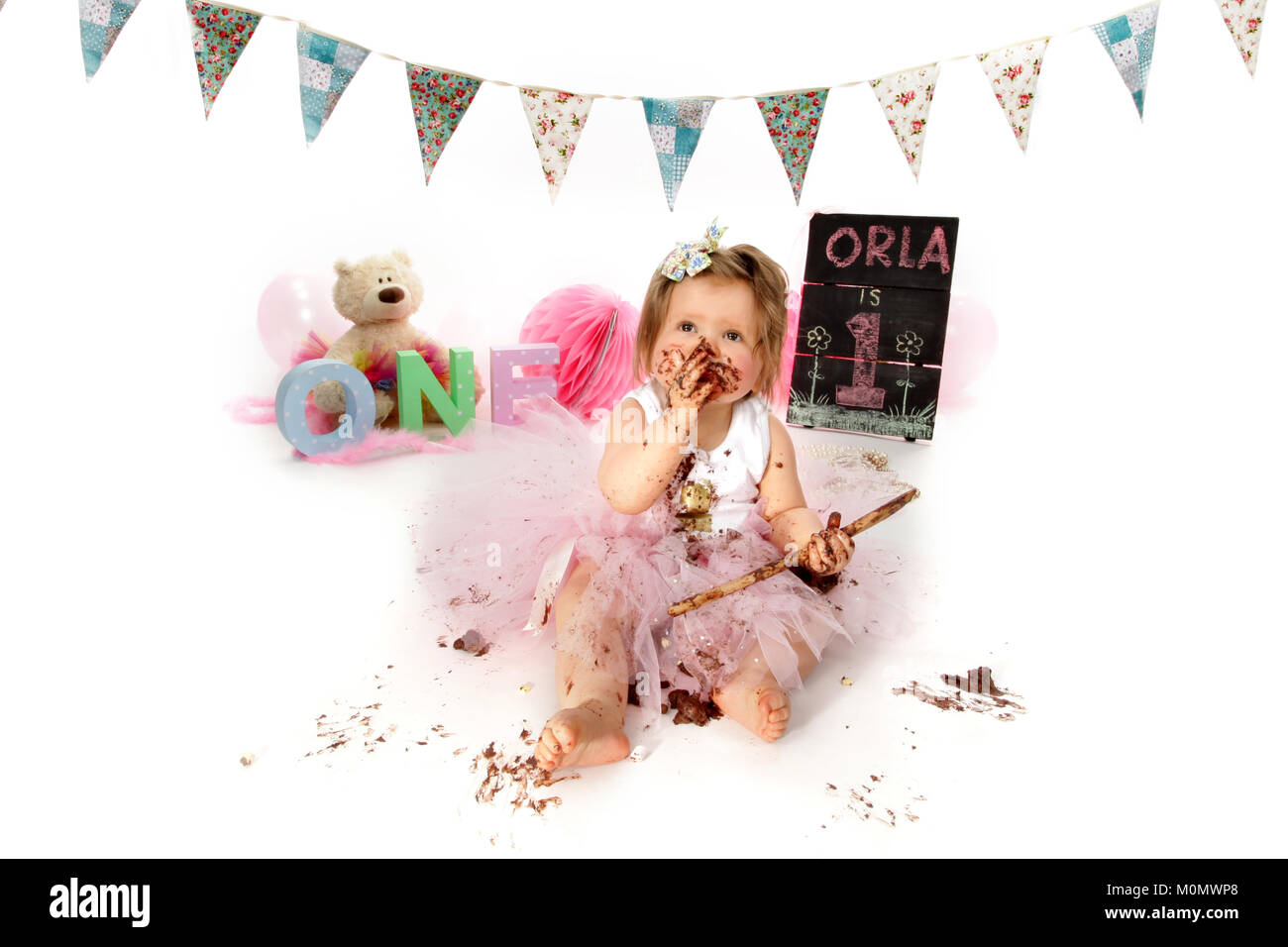 1 year old girl birthday party, cake smash, messy chocolate cake Stock Photo