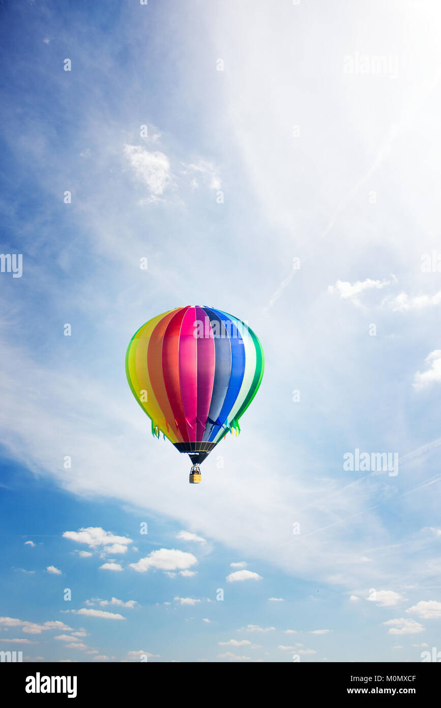 Colorful hot-air balloon flying high up in summer across blue sky Stock ...