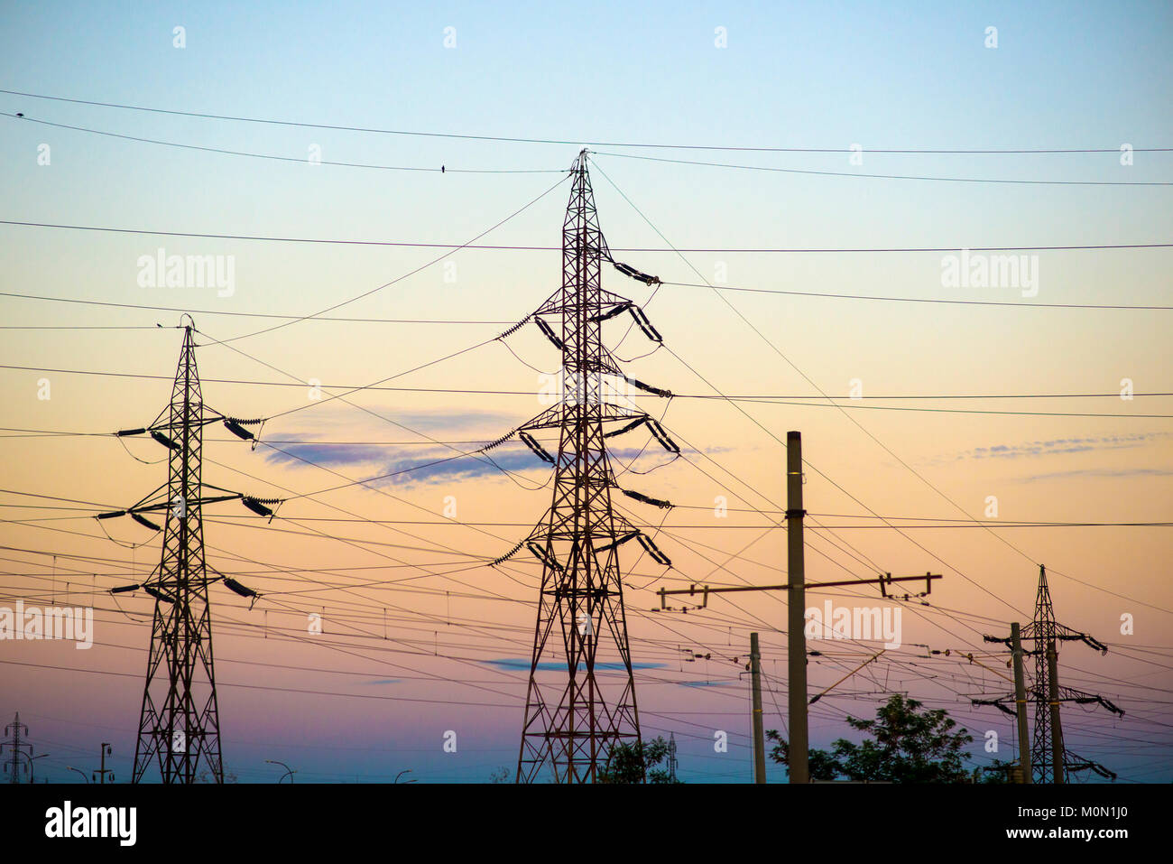 High voltage transmission lines for elecrticity during sunset Stock Photo