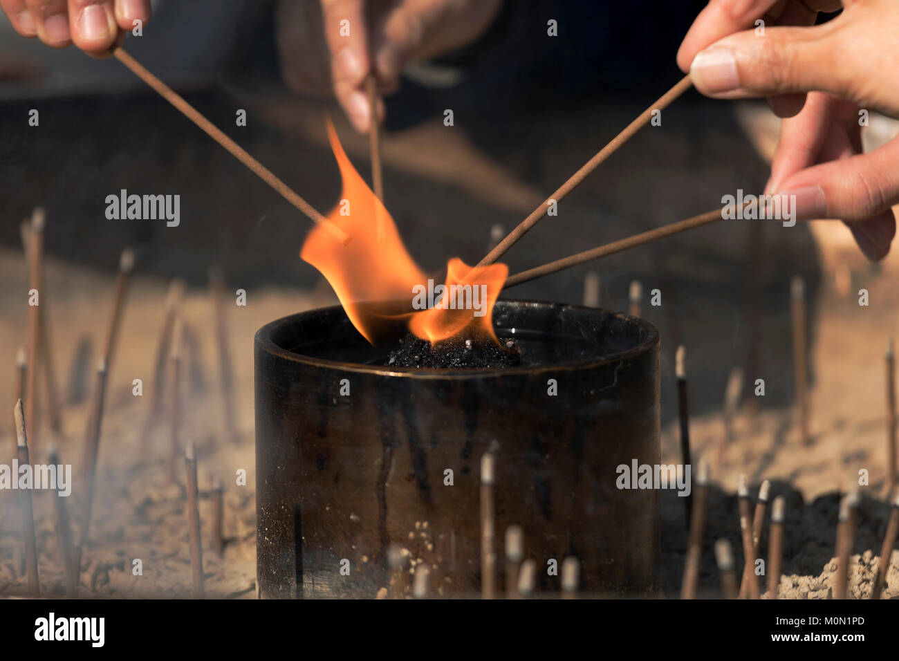 Hands lighting incense sticks on open flame Stock Photo Alamy