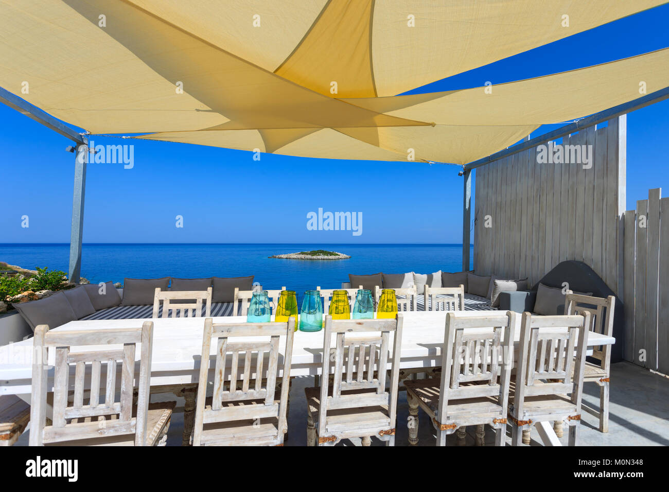 big table with chair close to the beach in a summer resort in Greece