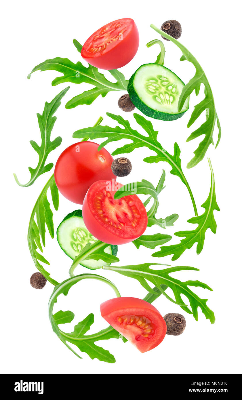 Falling vegetables salad. Cherry tomatoes, rucola and cucumber isolated on white background Stock Photo