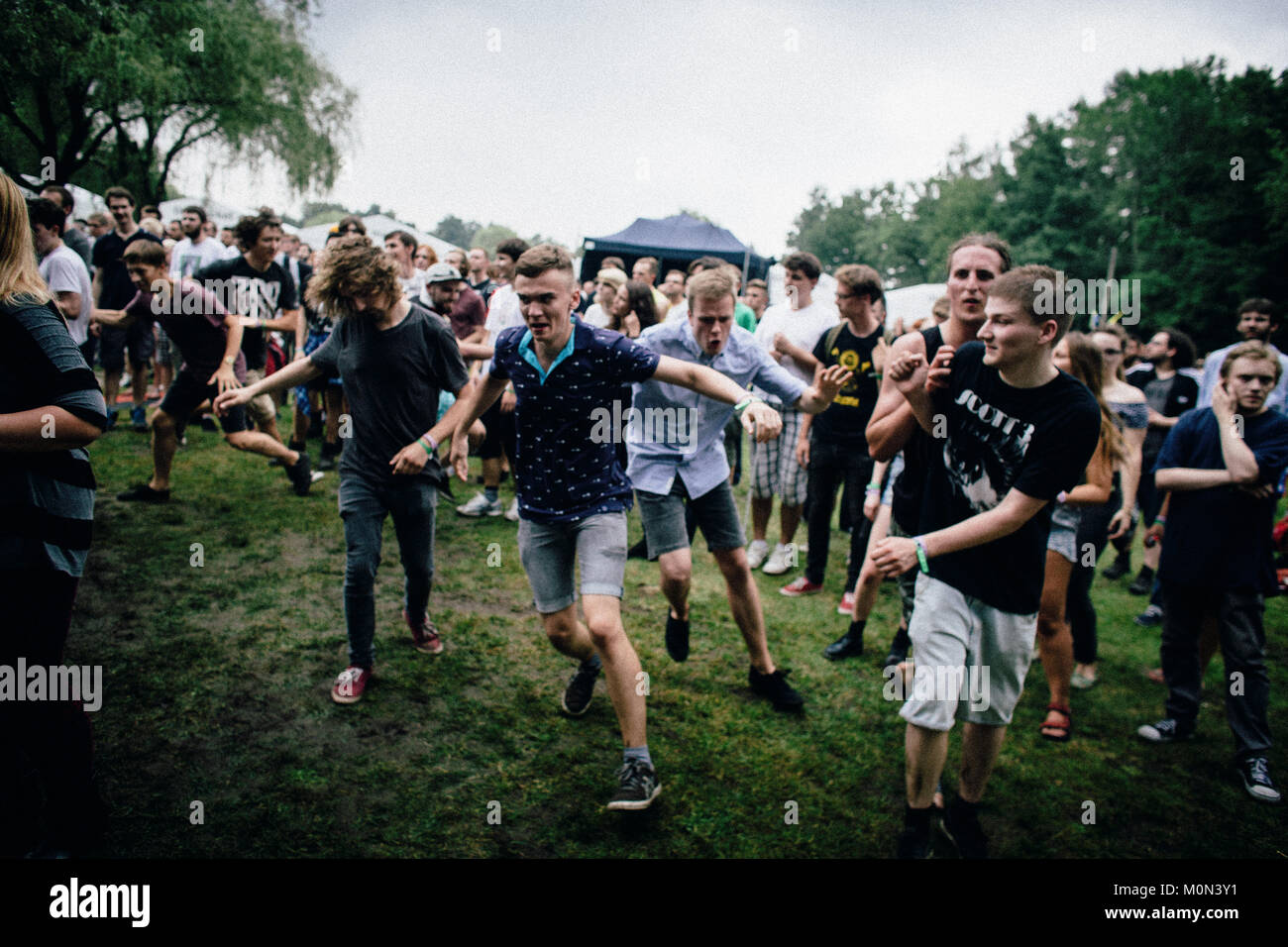 A group of Polish punk and music fans have a great and energetic time dancing around like crazy in front of the stage when the American punk band Cerebral Ballzy gave concert at the Off Festival 2014 in Poland, 01/08 2014. Stock Photo