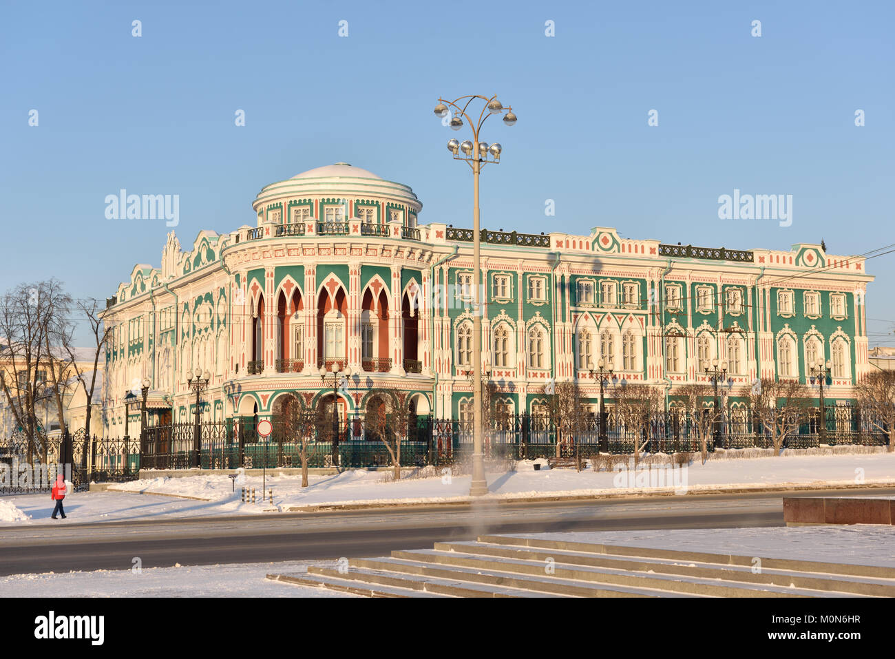 Yekaterinburg, Russia - January 2, 2015: Man near the House of N. I. Sevastianov in a winter day. Built in the first quarter of XIX century Stock Photo
