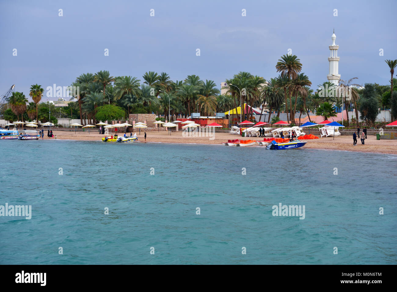 Aqaba, Jordan - March 14, 2014: Boats on the beach of Aqaba in springtime. Glass bottom boats allow tourists to see corals and fishes Stock Photo