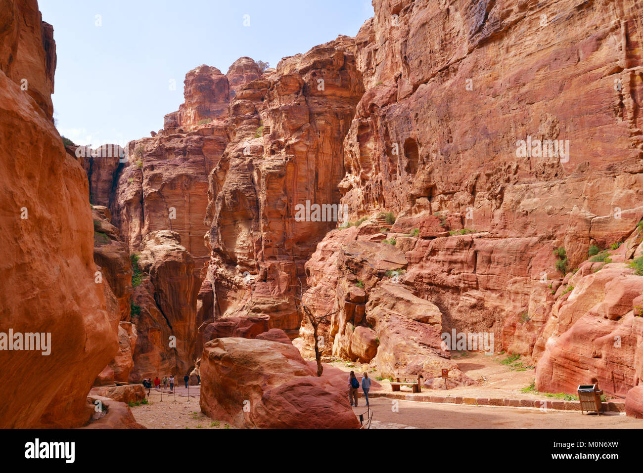 Petra, Jordan - March 15, 2014: Tourists walks in the Siq, the canyon of ancient Petra. Since 1985, Petra is listed as UNESCO World Heritage site Stock Photo