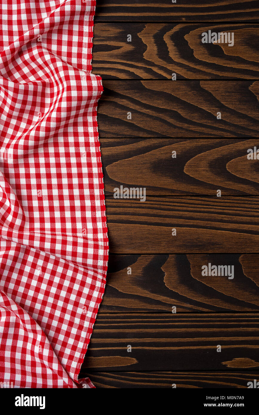 Red checkered tablecloth on an old wooden table. Close up Stock Photo