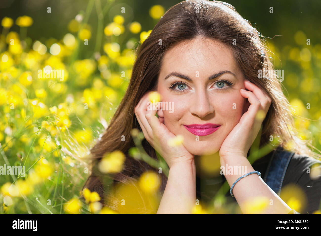 portrait of a beautiful young girl among yellow flowers in the nature ...