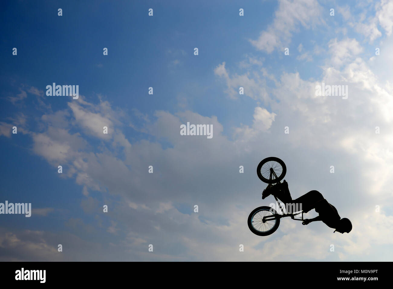 Extreme biker is doing a trick in the air on his bike Stock Photo