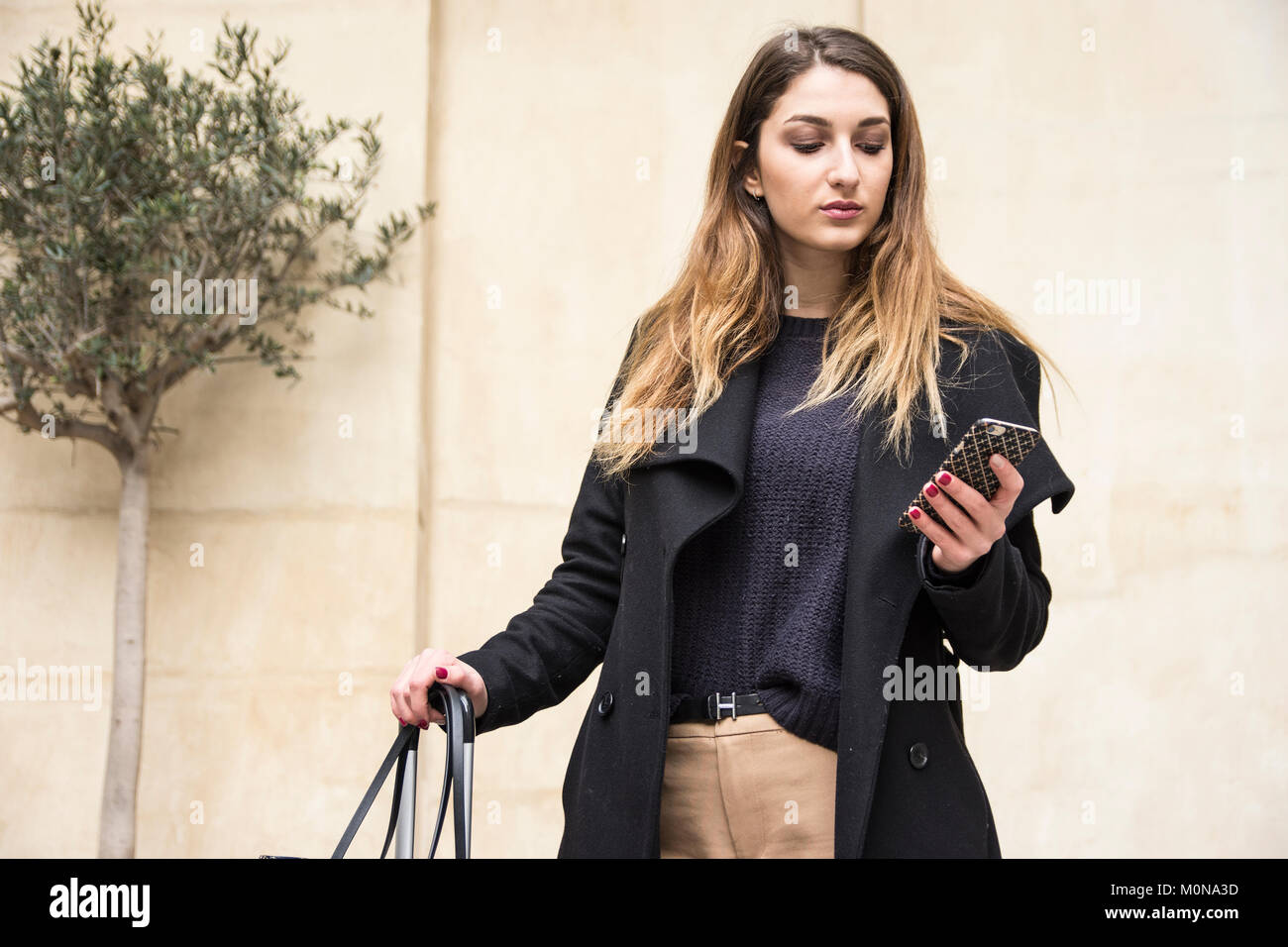 Young Professional Female On Mobile Phone Standing Against Blonde