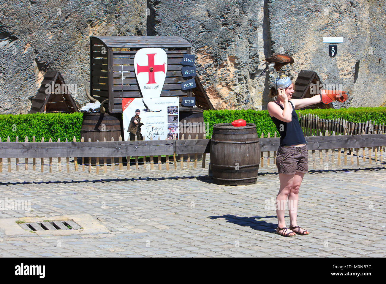 A tourist with a hawk on her head during a show at the 10th-century Bouillon Castle in Bouillon, Belgium Stock Photo