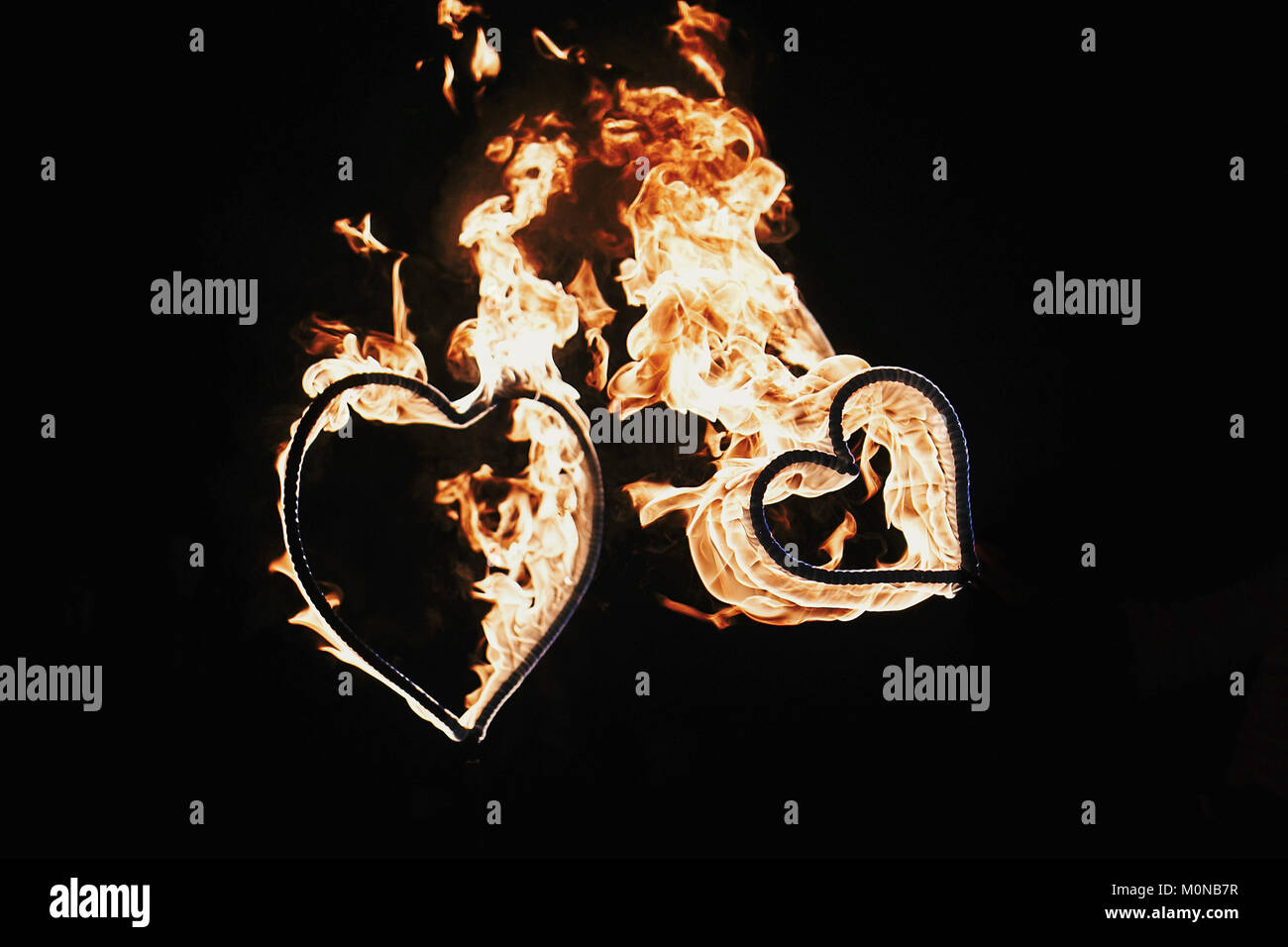happy valentine's day card. two hearts shaped fireworks on black background, fire show in night. bengal fire burning heart. space for text. wedding or Stock Photo