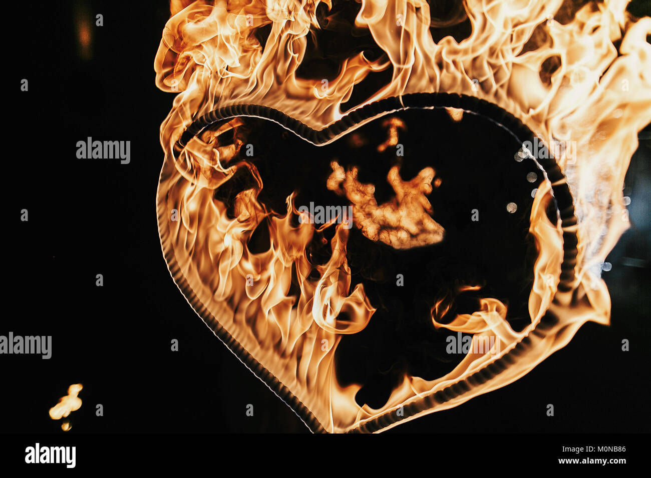 heart shaped firework on black background, fire show in night. happy valentine's day card. bengal fire burning heart. space for text. wedding or valen Stock Photo