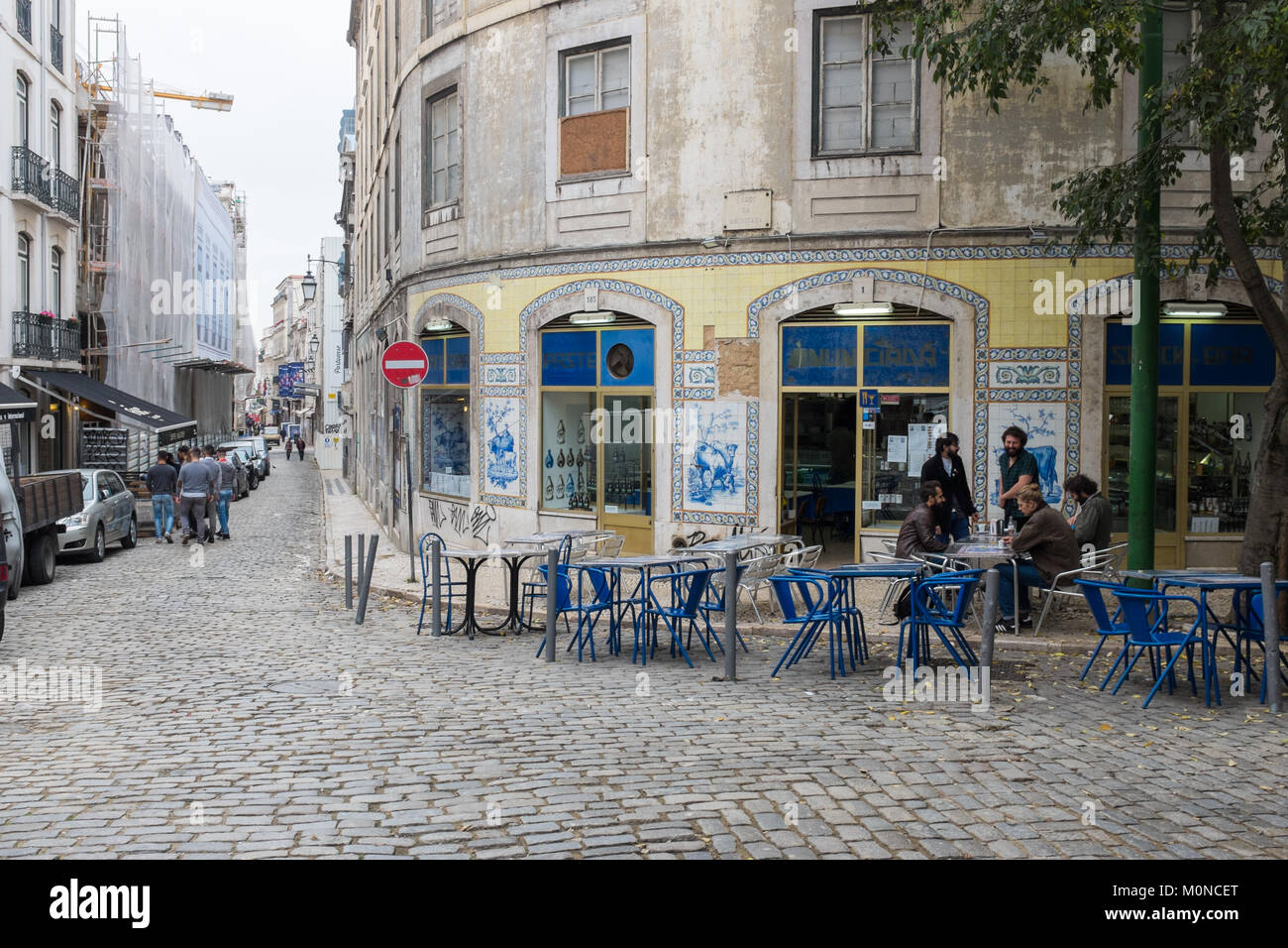 Traditional cafe on a cobbled street with outdoor tables and chairs in Lisbon, Portugal Stock Photo