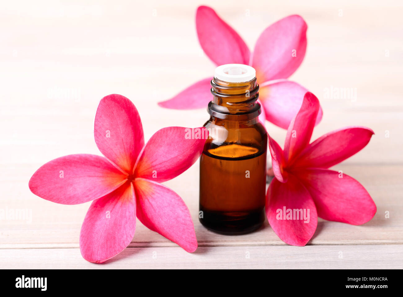 plumeria flowers and Plumeria Essential Oil Perfume on the wooden table