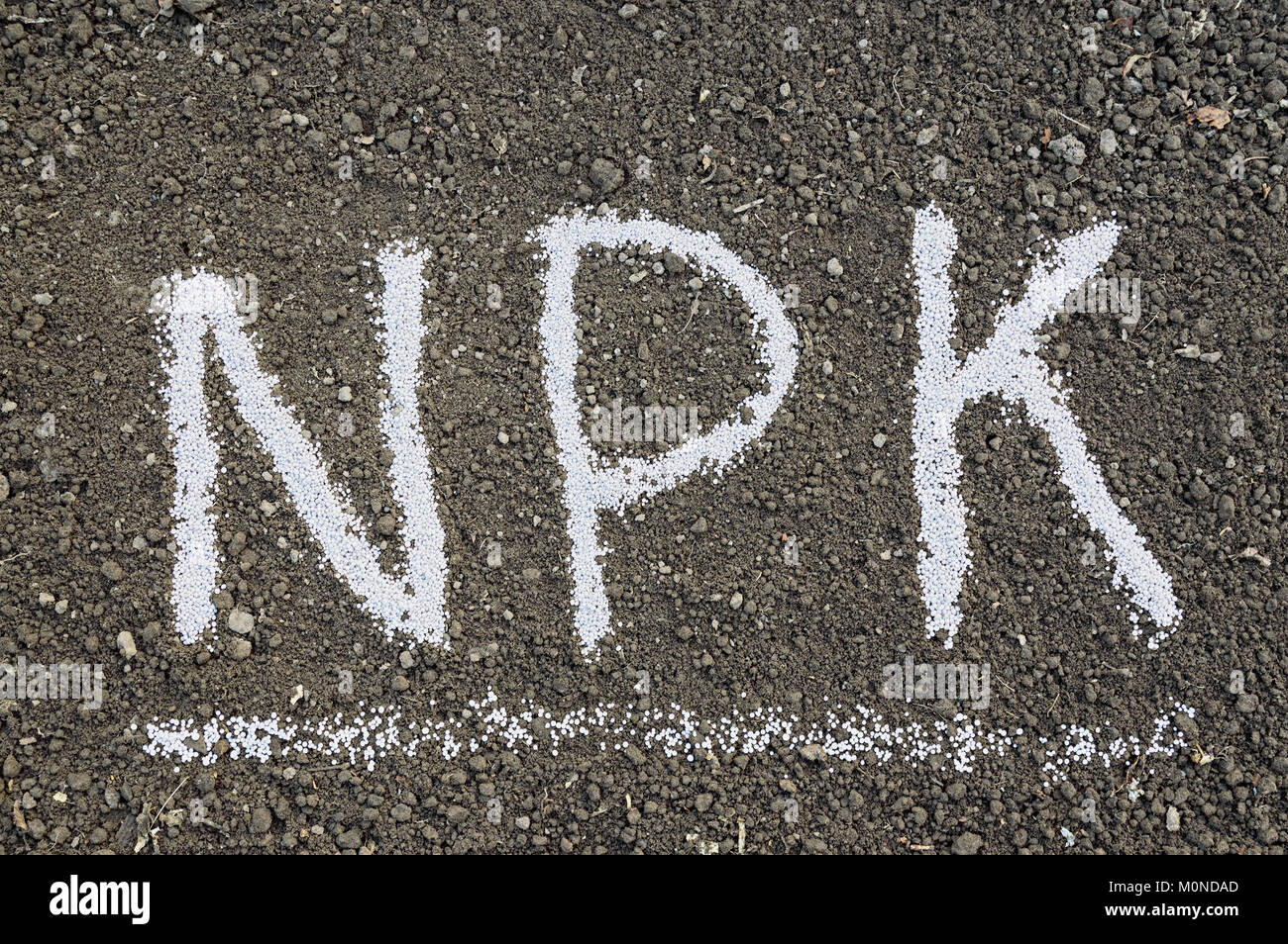 NPK letters made of composite mineral fertilizers on the black soil ...