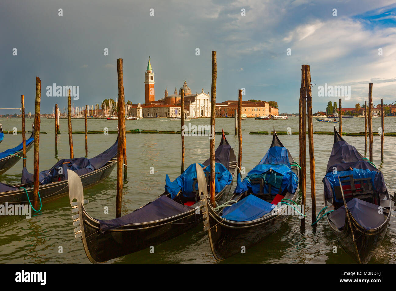 San Giorgio Maggiore church and Gondolas with dramatic sky after rain ...