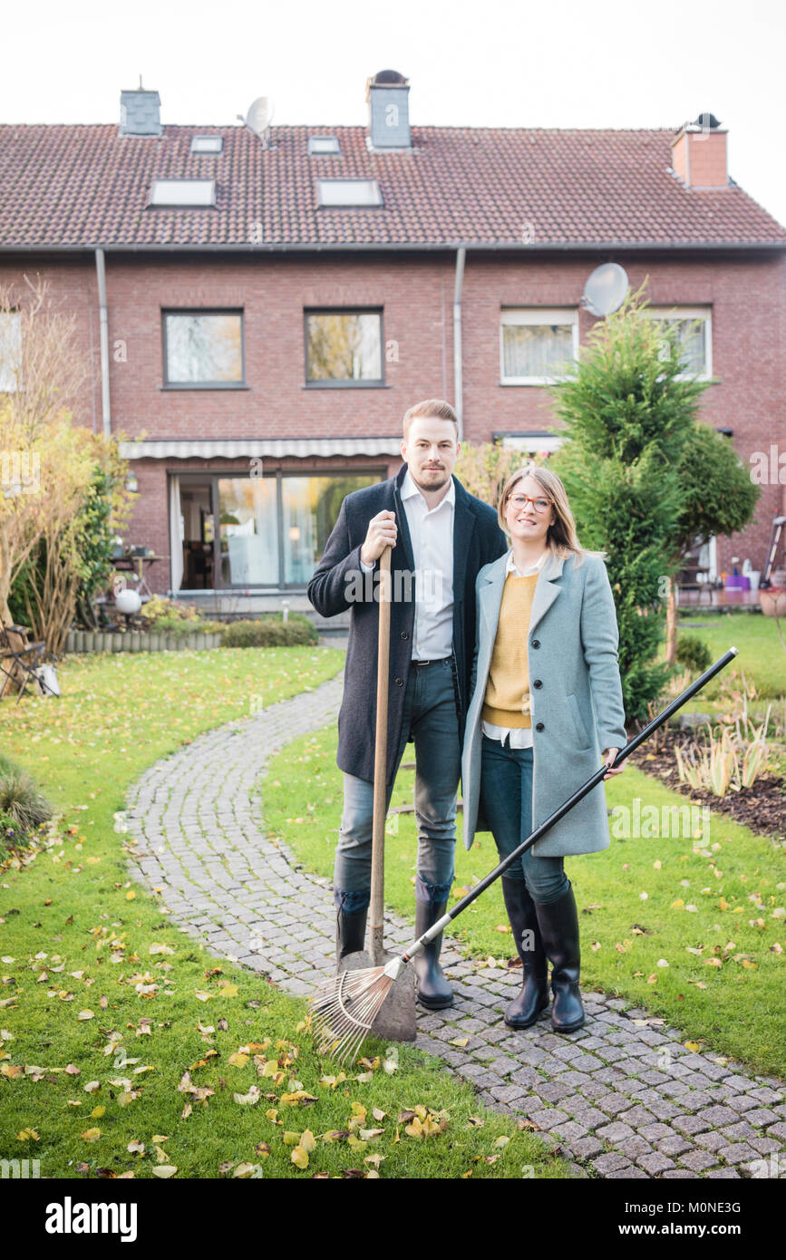Portrait of couple standing in garden in autumn Stock Photo