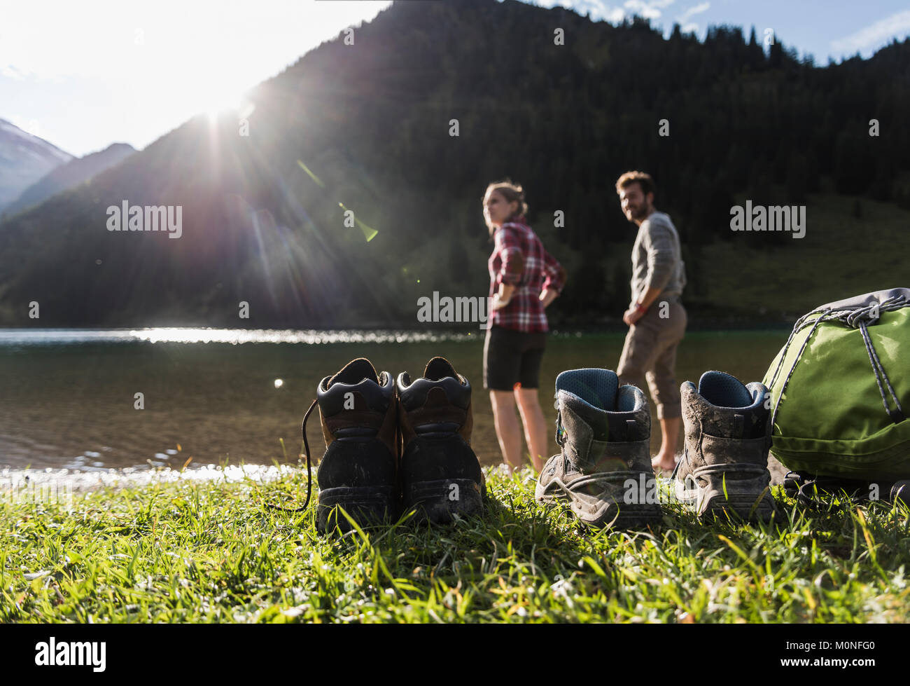 Austria, Tyrol, hiking shoes and couple refreshing in mountain lake Stock Photo