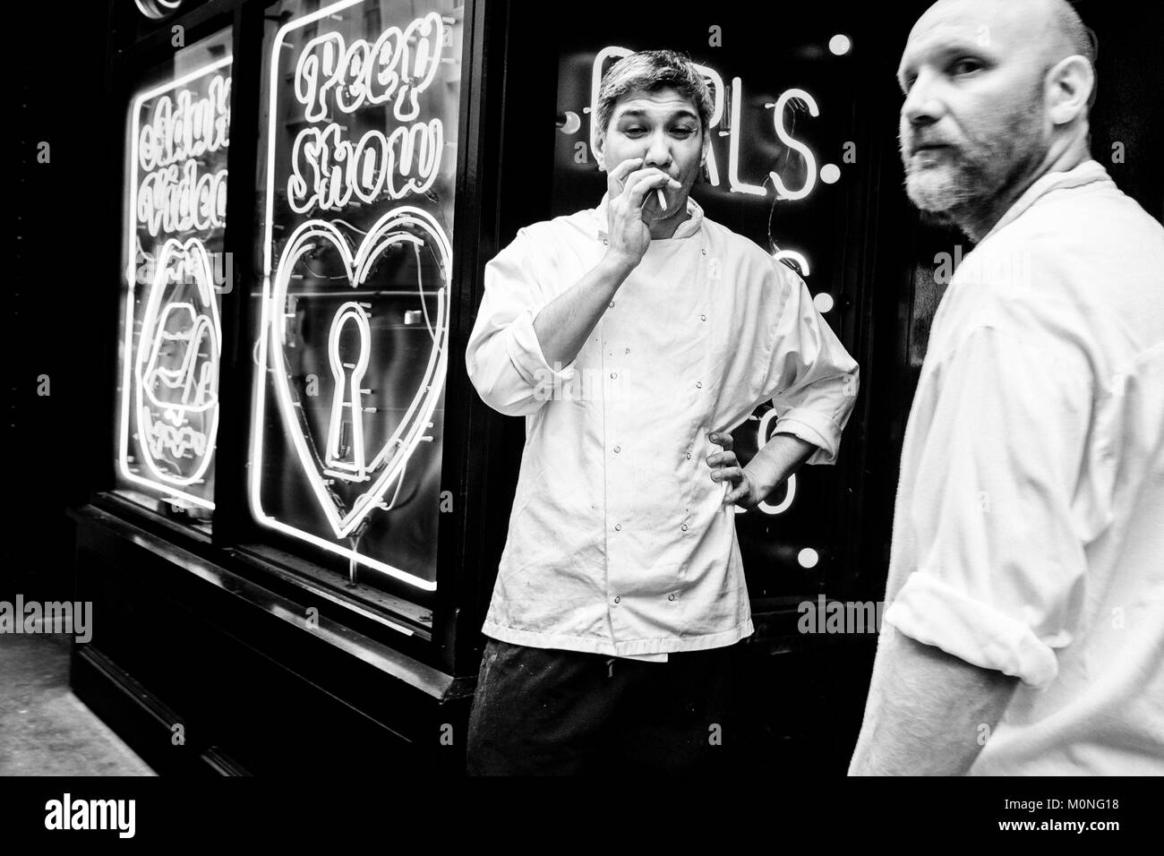 London black and white street photography: Two restaurant kitchen staff on break, Soho, London. Stock Photo