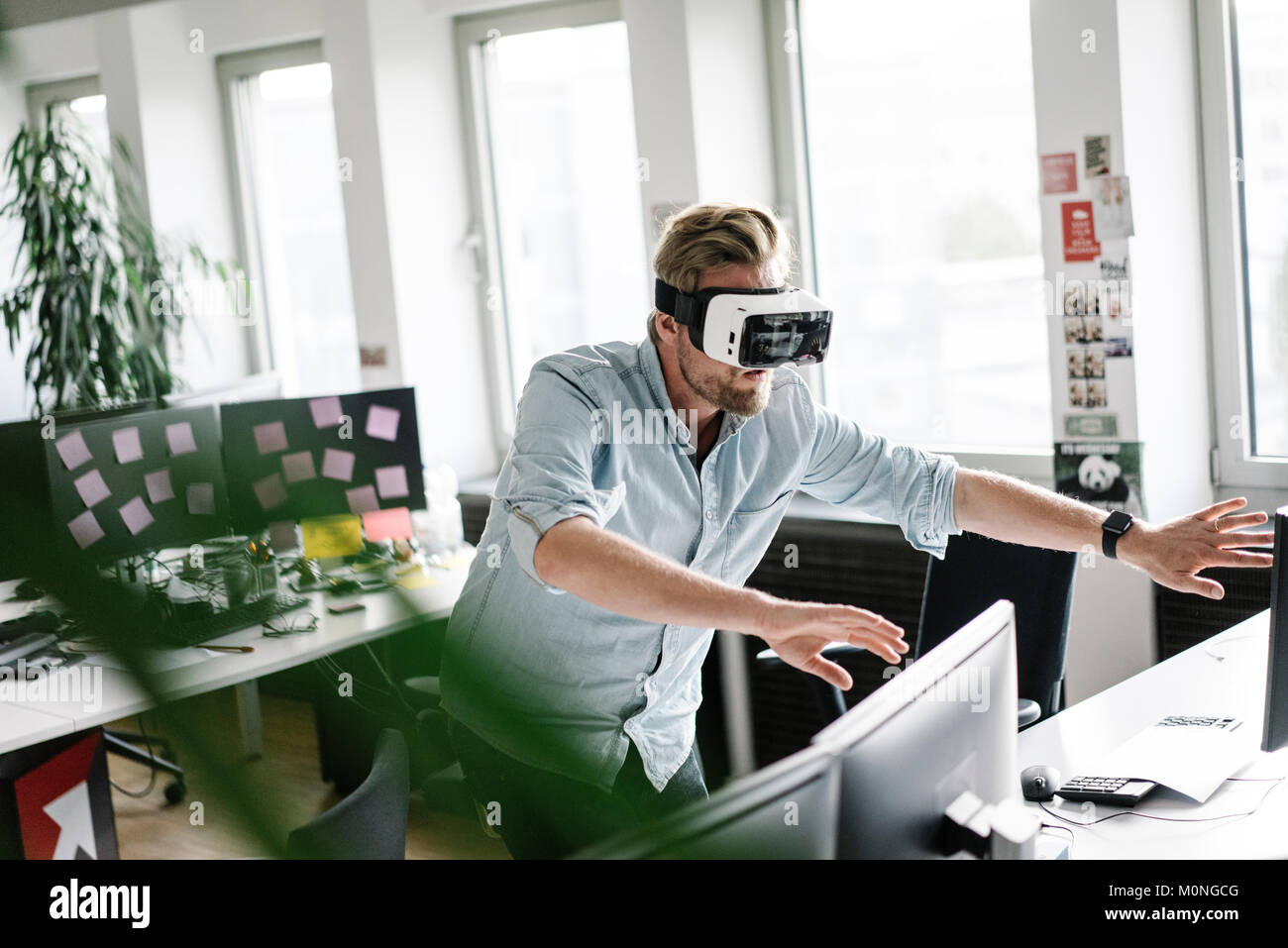 Businessman wearing VR glasses in office Stock Photo - Alamy