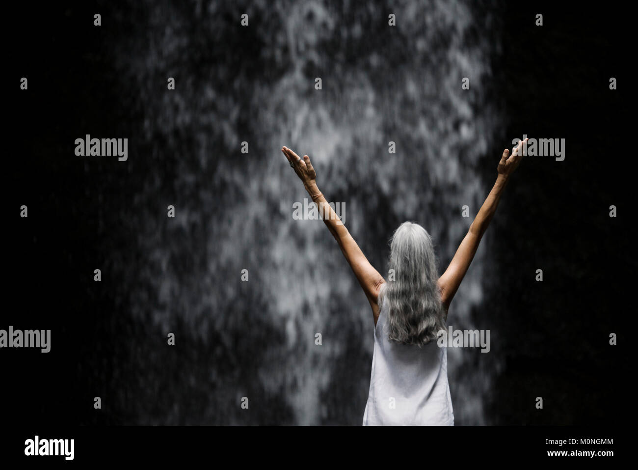 Beautiful senior woman standing in front of a tropical waterfall Stock ...