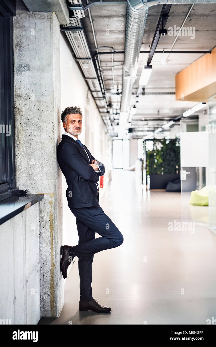 Portrait of confident mature businessman standing in office Stock Photo ...