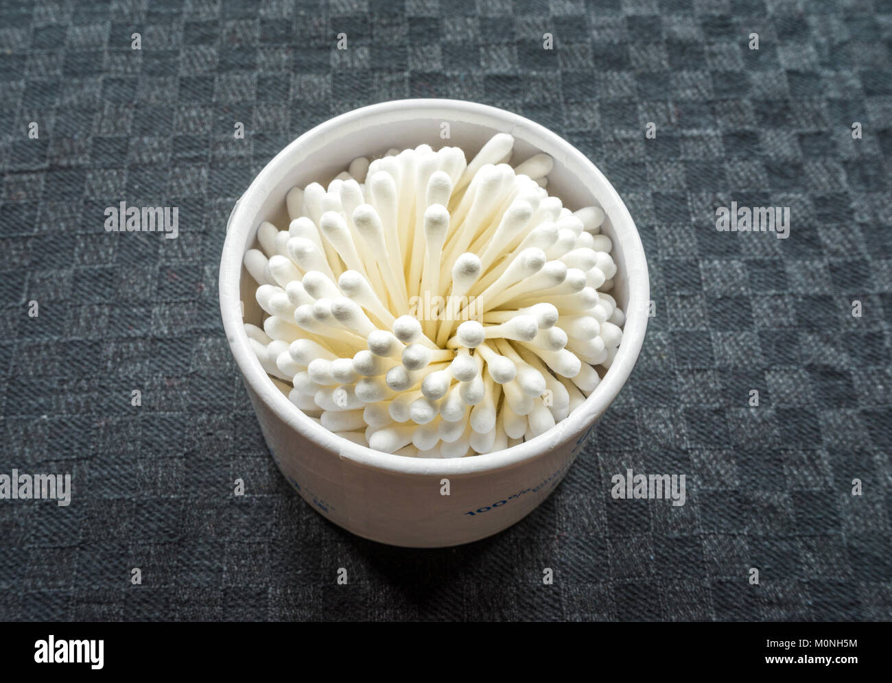 High angle view of a box of paper stemmed white cotton buds against black background Stock Photo