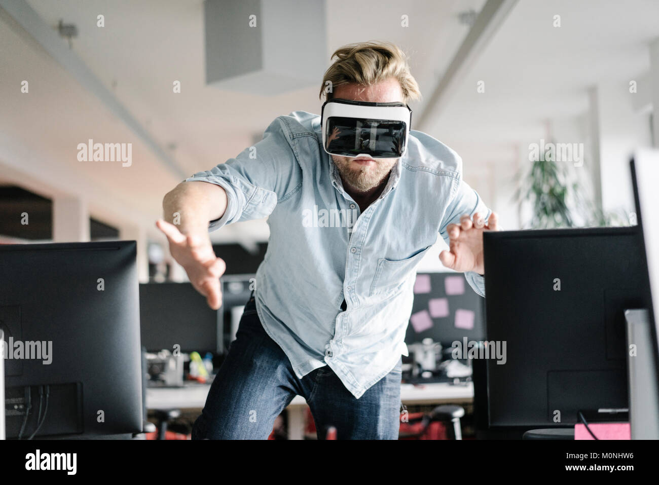 Businessman wearing VR glasses in office Stock Photo - Alamy