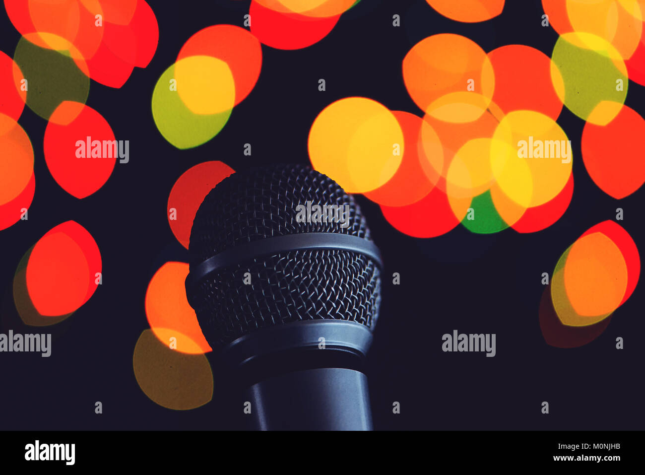 Audio microphone in karaoke bar with festive bokeh light background Stock Photo