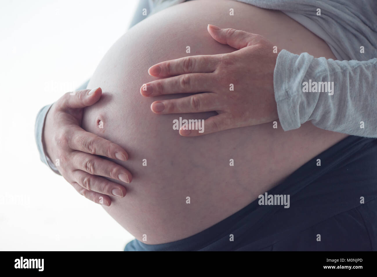 Pregnant woman tummy, female person in ninth month of pregnancy posing Stock Photo