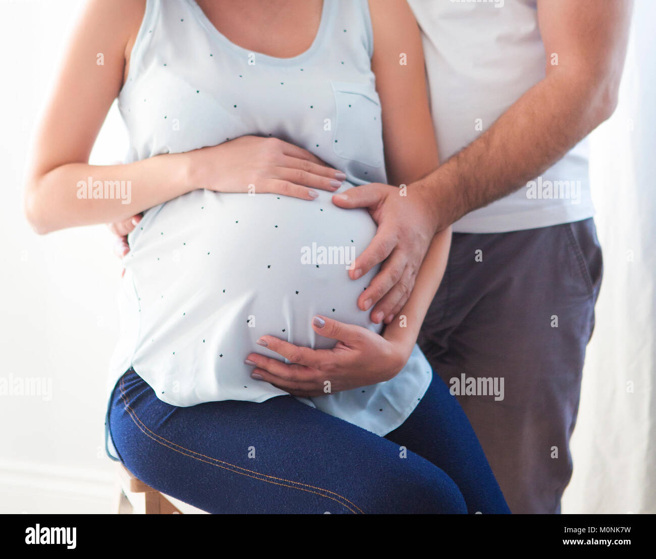 Pregnant woman and young man together indoors Stock Photo - Alamy