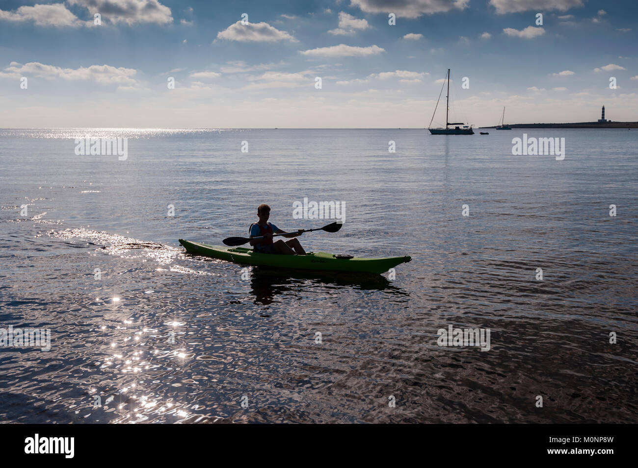 A teenage boy in a Kayak at Punta Prima , Menorca , Balearic Islands , Spain Stock Photo