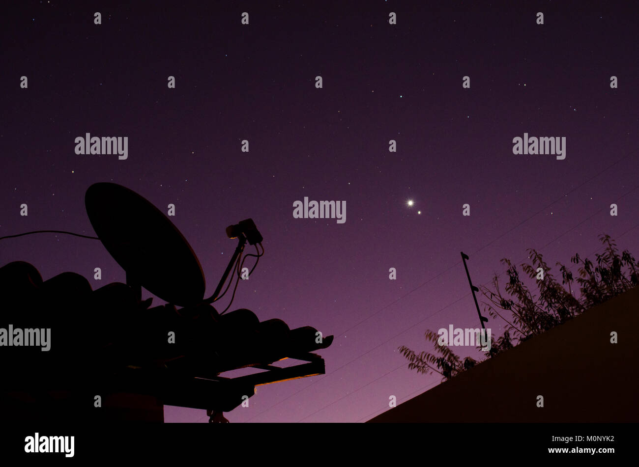 Antenna pointing to purple and starry night sky Stock Photo