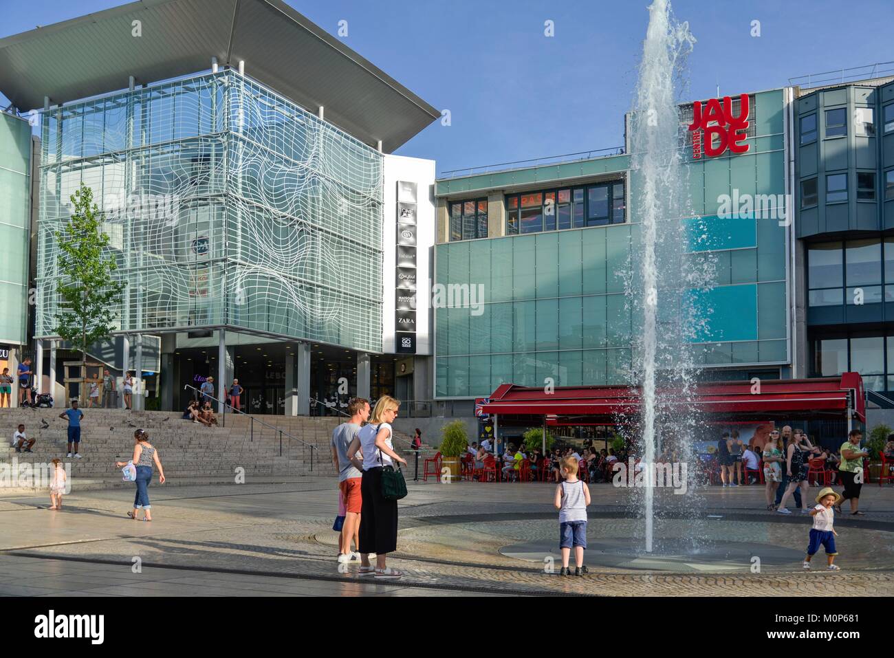 France,Puy de Dome,Clermont Ferrand,Place of Jaude,children with their  parents at the foot of a water jet with a shopping mall in the background  Stock Photo - Alamy