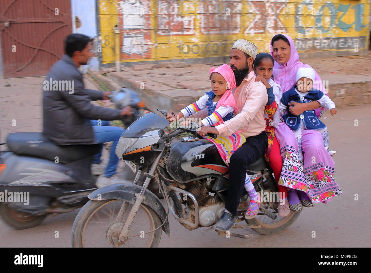 BUNDI, RAJASTHAN, INDIA - DECEMBER 10, 2017: Local transport with a smiling family travelling on a motorcycle in the streets of the old town Stock Photo