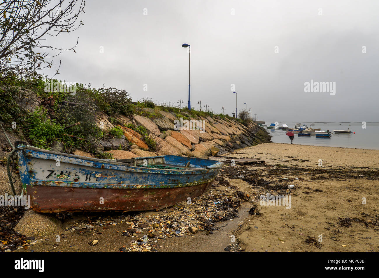 An old boat sitting on a quiet beach - Vigo, Galicia - Spain Stock Photo