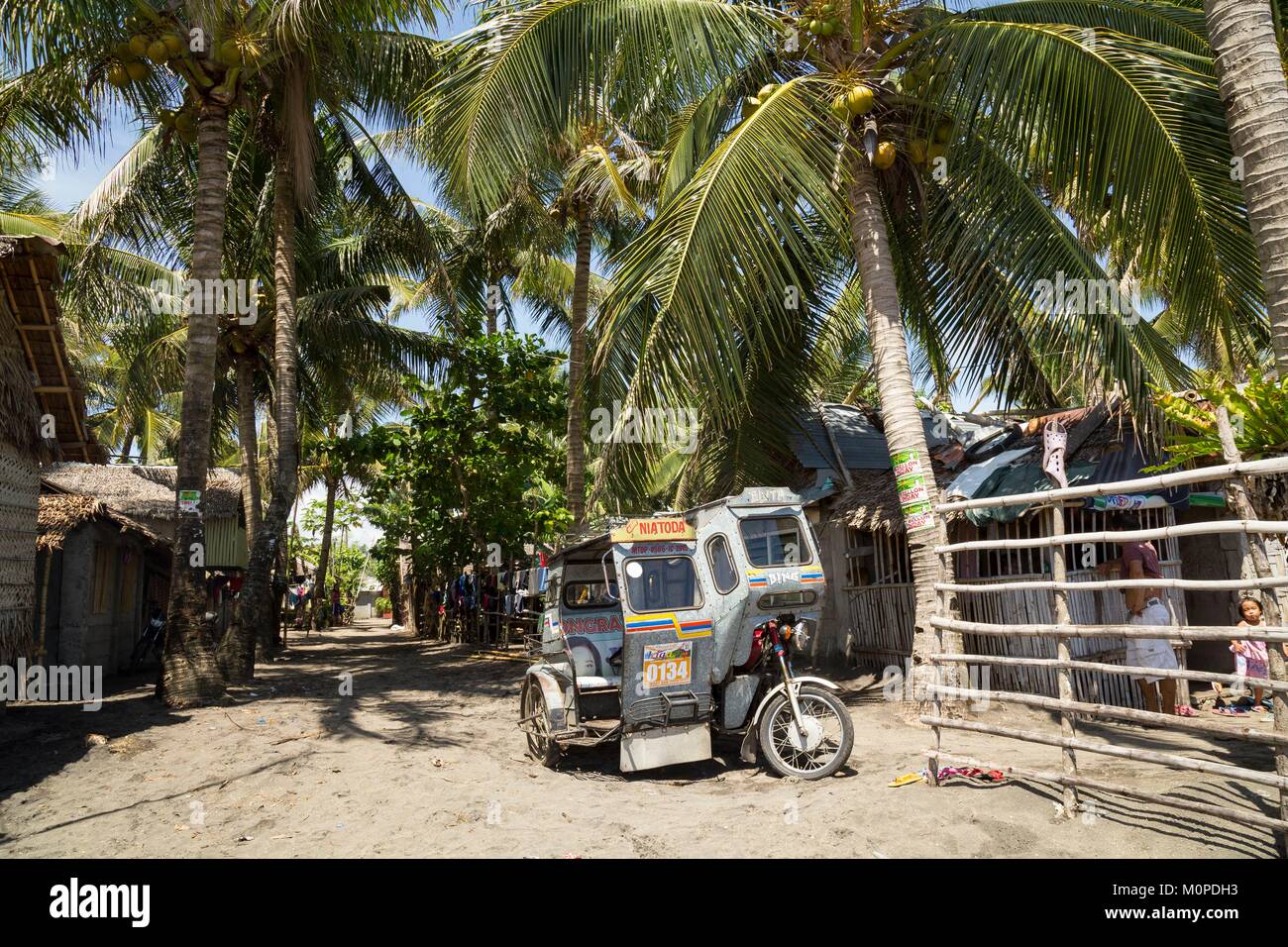 Philippines,Luzon,Camarines Sur Province,Sagnay,Nato fishermen village,tricycle in the sandy road Stock Photo