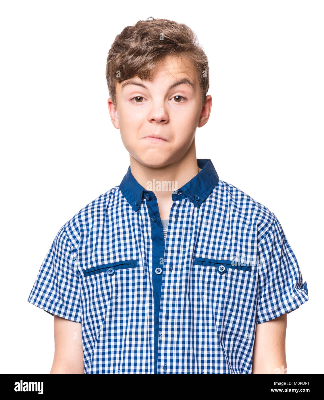 Teen boy making silly grimace - funny surprised face. Playful child isolated on white background. Emotional portrait of caucasian teenager looking at  Stock Photo