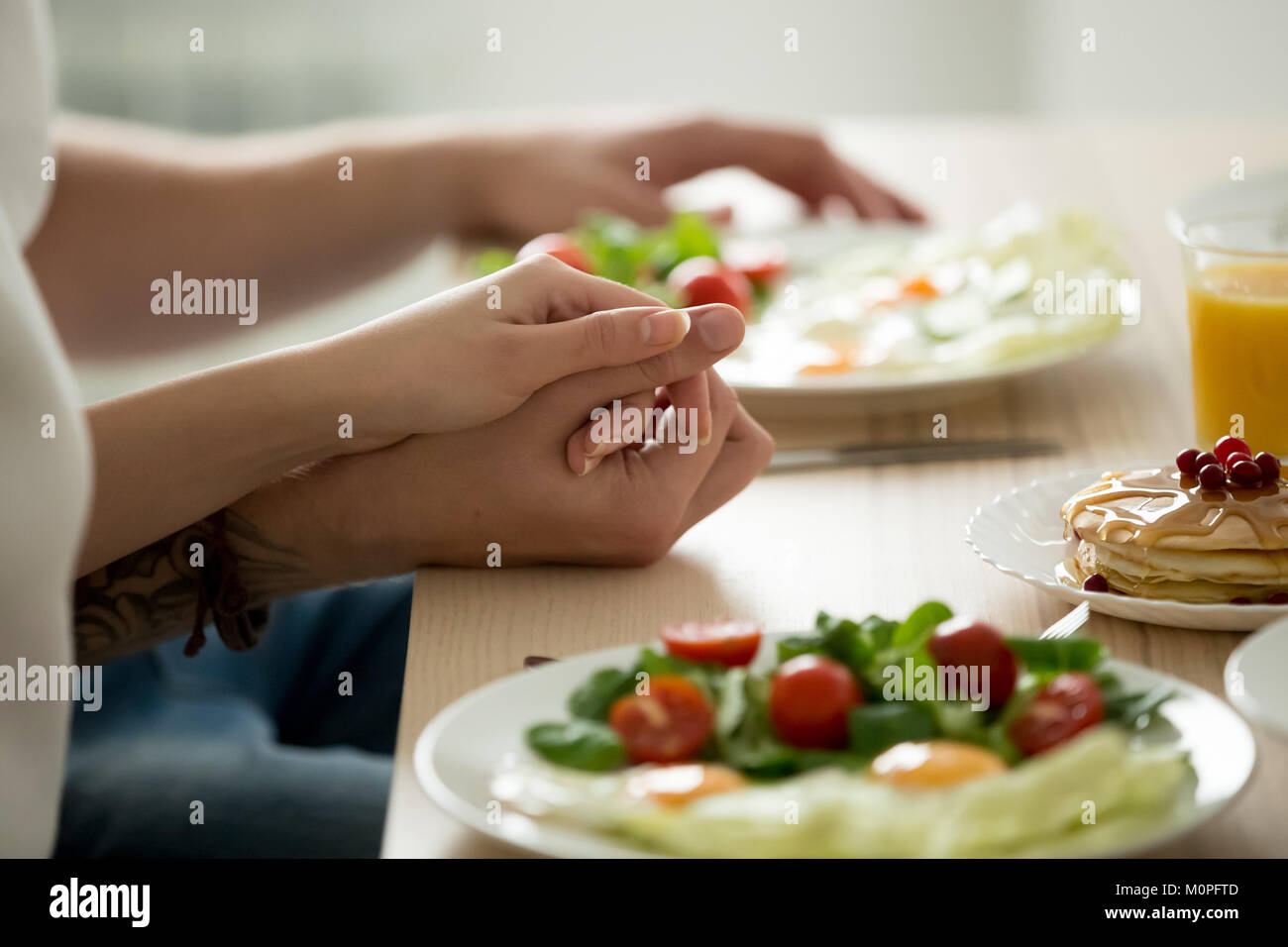 Couple holding hands enjoying healthy breakfast together, close  Stock Photo