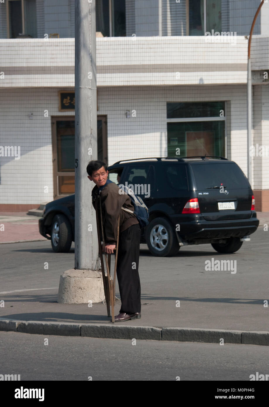North Korean man with crutches in the street, Pyongan Province, Pyongyang, North Korea Stock Photo