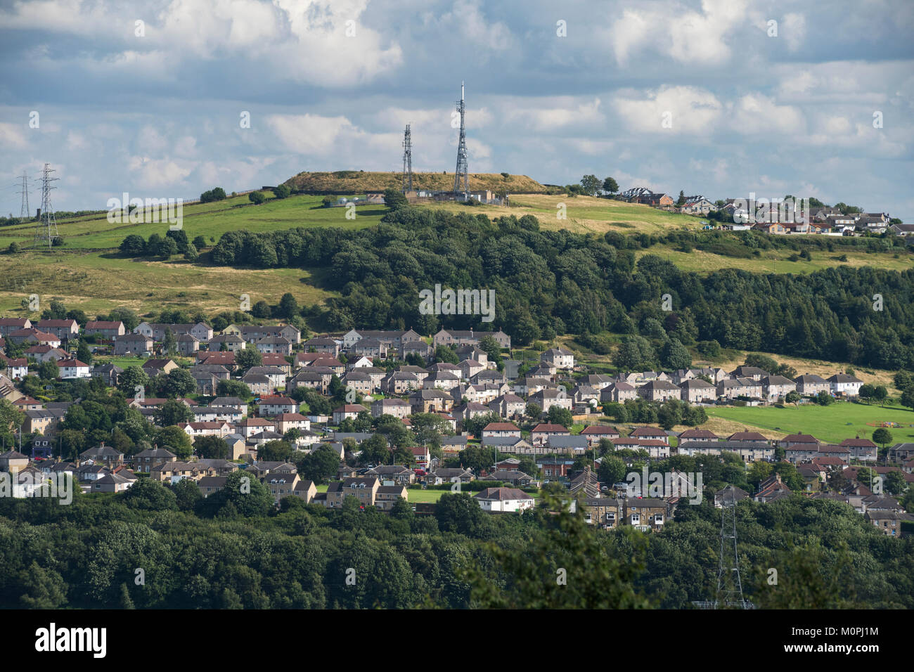 Hillside suburban area with housing, green fields, woodland & transmitters  on sunny day - Shipley & Idle areas of Bradford, West Yorkshire, GB, UK. Stock Photo