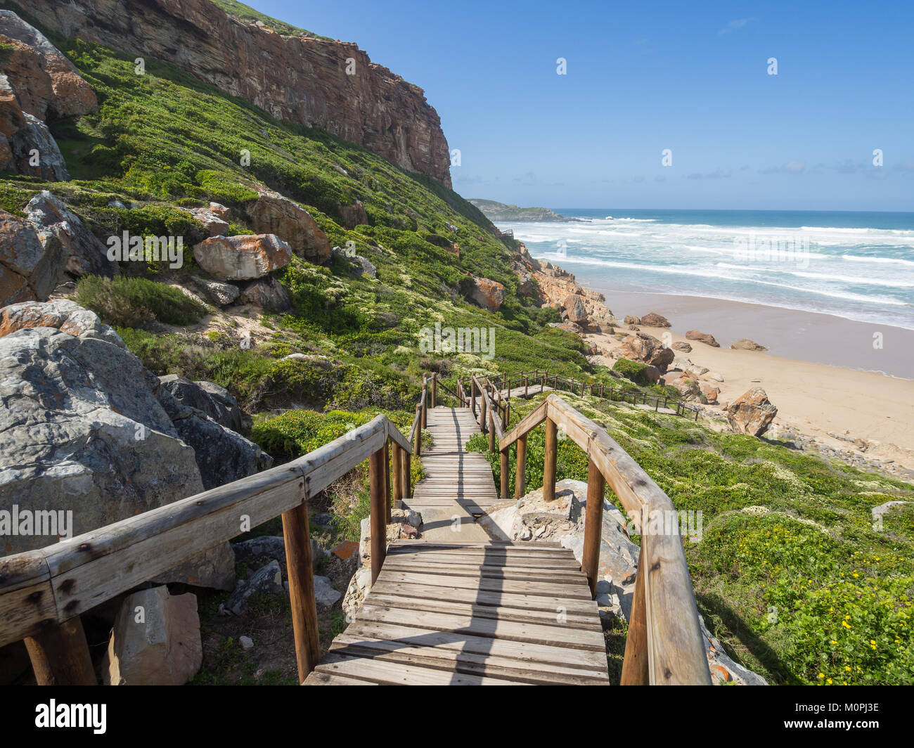 Garden Route - Robberg Nature Reserve - Wooden walkway leading down to beautiful beach and ocean on Robberg Island Stock Photo